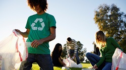 college students recycling plastic on grass