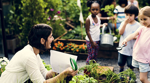 Teacher and students learning in garden, Shutterstock