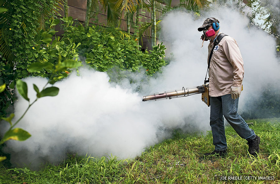 “: Carlos Varas, a Miami-Dade County mosquito control inspector, uses a Golden Eagle blower to spray pesticide to kill mosquitos in the Miami Beach neighborhood as the county fights to control the Zika virus outbreak on August 24, 2016 in Miami Beach, Florida.